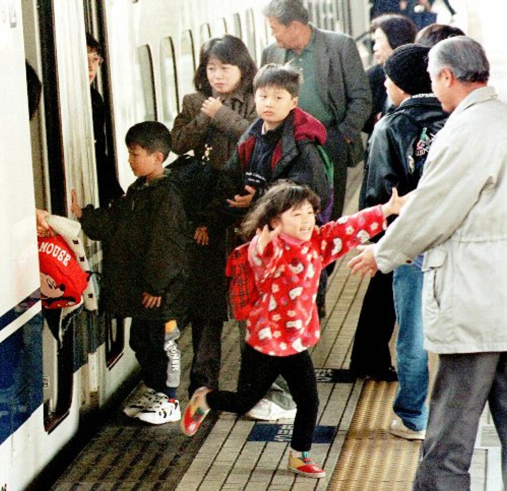 帰省客で混雑するホームで、出迎えの親類に駆け寄る女の子　（１９９８年１２月、JR名古屋駅で）